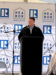 NEA Board of Realtors Speaker stands at a podium